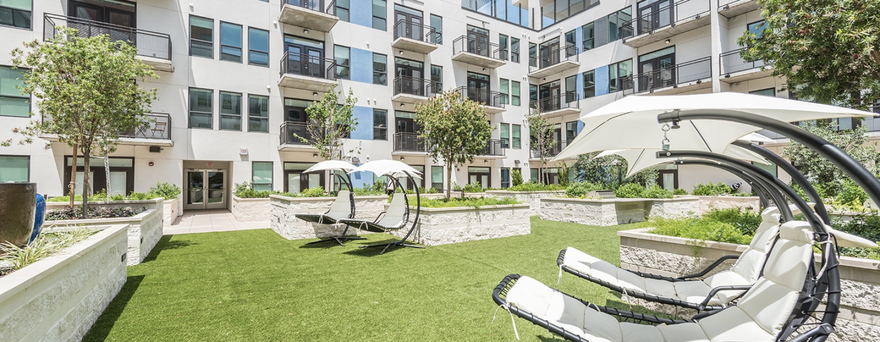 The shared outdoor space with shaded hammocks at Eighteen25 apartments in Houston, TX